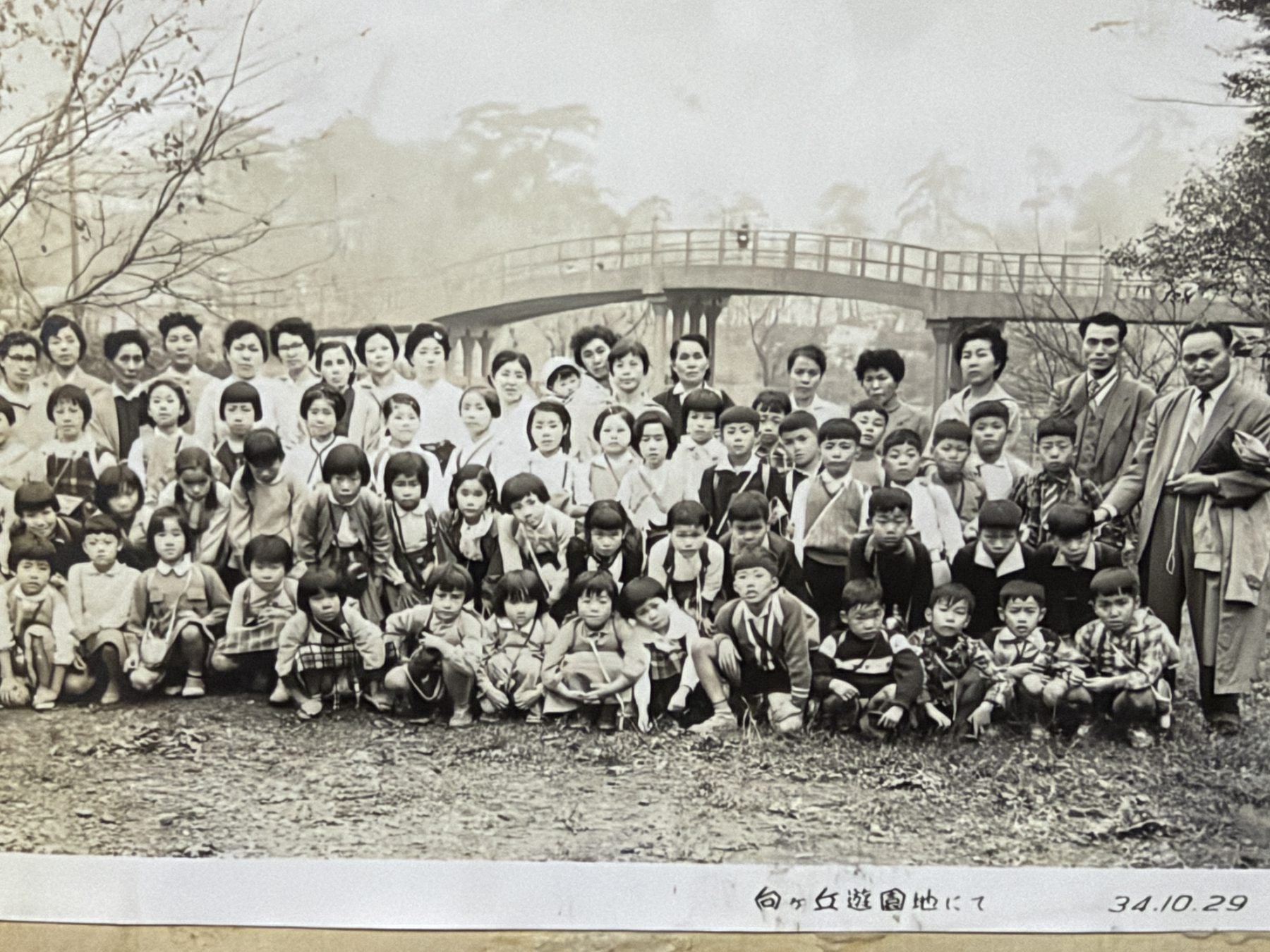 橋を背景に並ぶ大人と子どもの集合写真